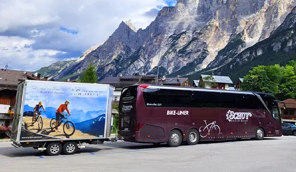 5* Schuy-Bikeliner-Bus mit passendem Fahrradanhänger vor einem Alpenpanorama während einer Schuy Radreise.