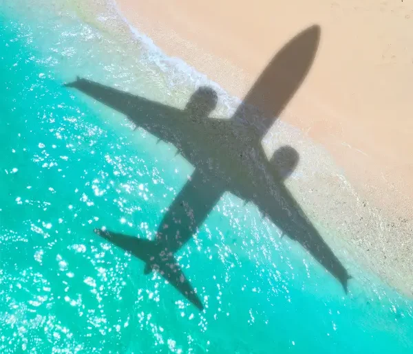 Flugzeugschatten am Strand während einer Flugreise.