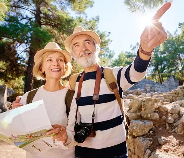 Älteres Paar mit Karte bei antiken Sehenswürdigkeiten auf einer Rund- & Studienreise.