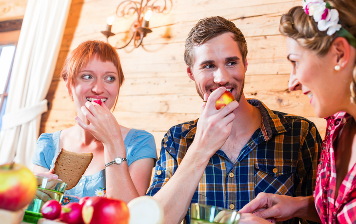 Freunde essen Brotzeit auf Berghütte