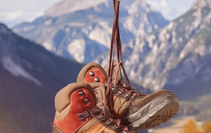 Wanderschuhe in den Bergen hängend