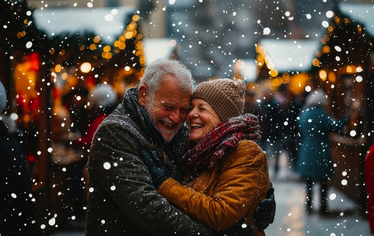 älteres Paar hat Spaß auf einem Weihnachtsmarkt