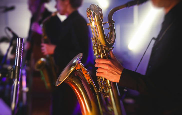 Konzertansicht eines Saxophonisten und musikalischer Jazzband im Hintergrund