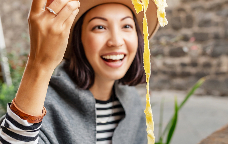 Frau isst Pasta mit Trüffel in einem italienischen Restaurant im Freien
