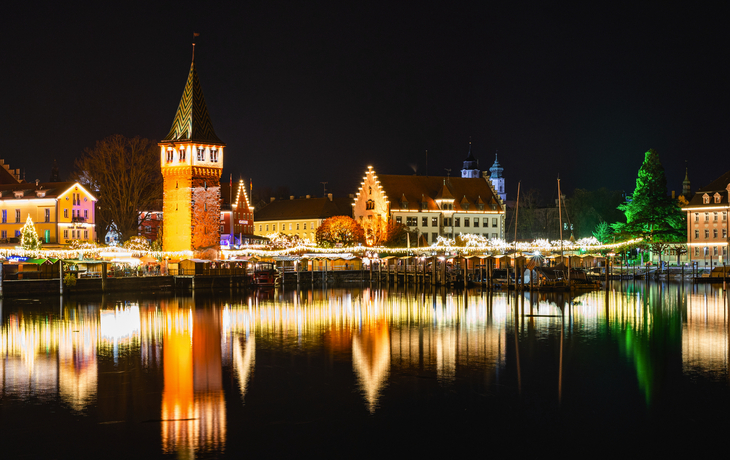 erleuchteter Hafen und Stadtkulisse in Lindau zur Hafenweihnacht 