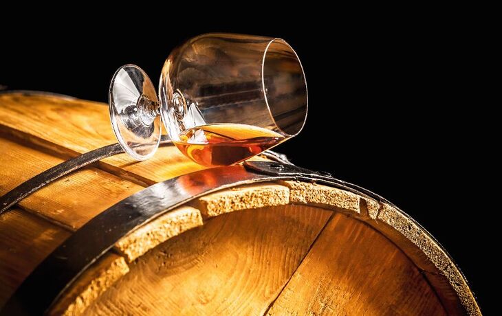 Glass of cognac on the vintage barrel