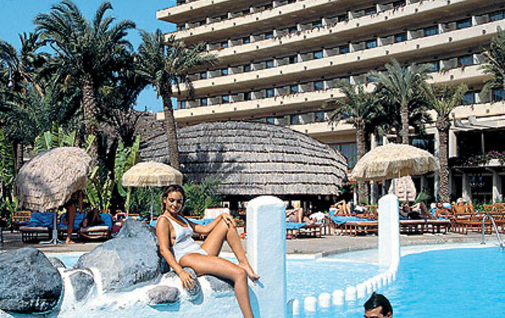 Hotel Gloria Palace mit Poolbereich und Gästen im Wasser.