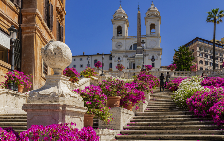 Perspektivisches Panorama der berühmten Spanischen Treppe mit der Kirche Trinita dei Monti der Obelisk im Zentrum von Rom,mit blauem Himmel,Wolken und Azaleen blühen Display.Rom,Italien.