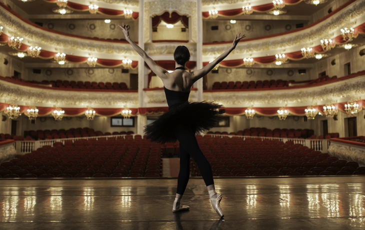 Ballerina, die auf Stadium des erstaunlichen Theaters und des lookng am Auditorium steht