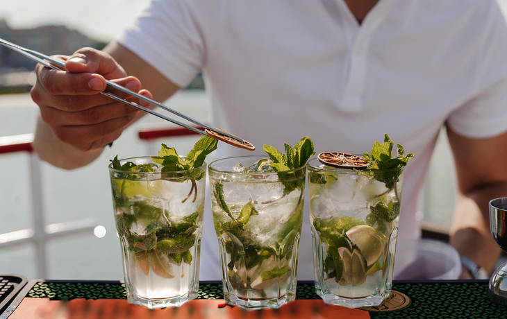 erfrischende Mojito-Cocktails mit frischer Minze und Limette auf einem sonnigen Deck