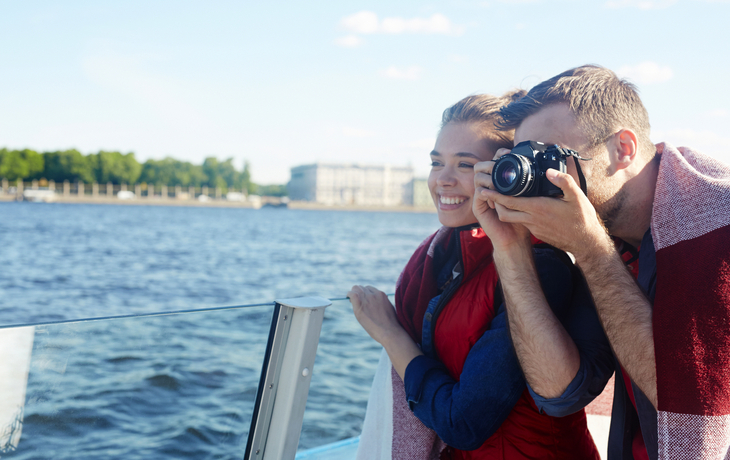 junger Mann fotografiert während einer Kreuzfahrt die Sehenswürdigkeiten des Flusses