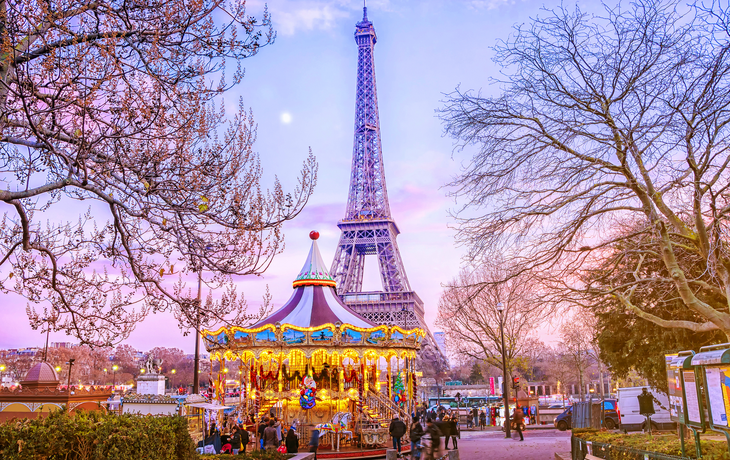 Eiffelturm hinter Karussell an einem Winterabend in Paris