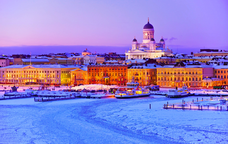Blick auf den vereisten Hafen in der Abenddämmerung im Winter in Helsinki, Finnland