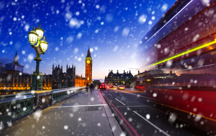 Big Ben und Westminster Bridge in einer kalten Winternacht mit fallendem Schnee