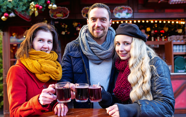 Apres Ski auf dem Weihnachtsmarkt, Mann, Frau, Paar, Freunde stoen mit heiem Glhwein an
