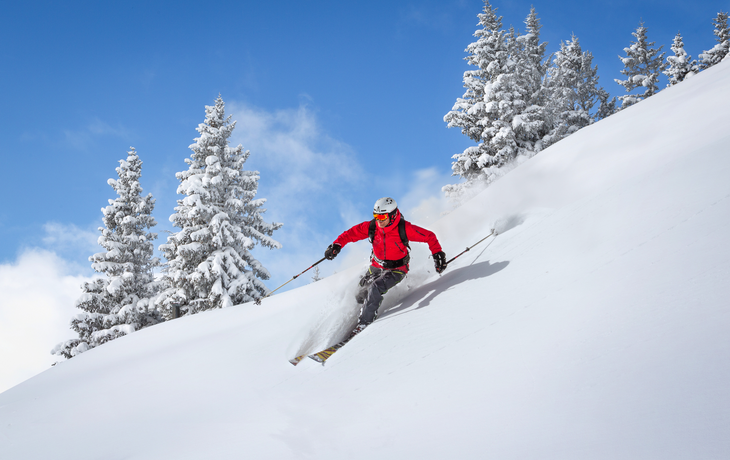 Freeride-Skifahrer fährt im tiefen Pulverschnee