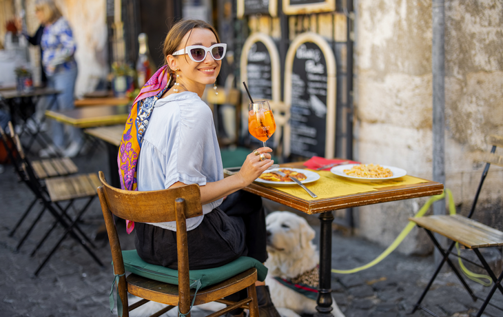 Frau isst italienische Pasta und trinkt Aperol Spritz im Restaurant auf der Straße in Rom