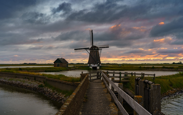 Kagerplassen-Windmühle an einem kleinen See bei Sonnenuntergang