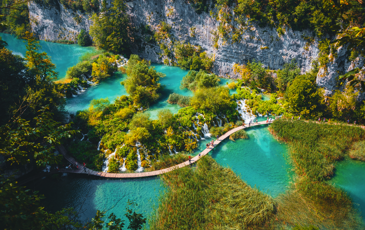 Luftaufnahme eines hölzernen Wanderwegs neben Wasserfällen im Nationalpark Plitvicer Seen