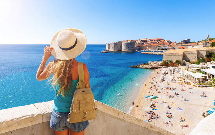 Touristin betrachtet die Stadt Dubrovnik und den Strand – Kroatien