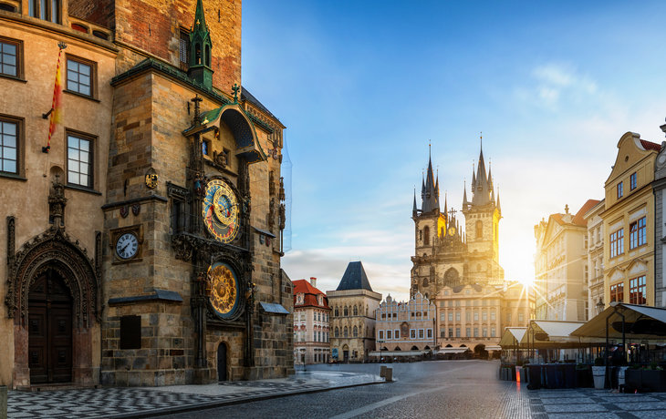 Bllick auf die Astronomische Uhr am Rathaus und die Marienkirche am zentralen Platz der Altstadt bei Sonnenaufgang, Prag