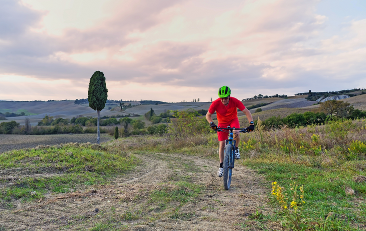 Mountainbiker fahren durch toskanische Landschaft