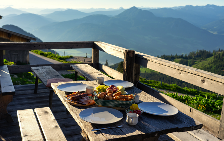 Frühstück in einer traditionellen Hütte auf einer Alm mit Obst und Wurst