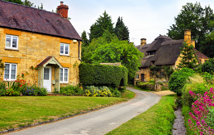 Dorf Stanton in den Cotswolds mit strohgedecktem Haus und Blumen 