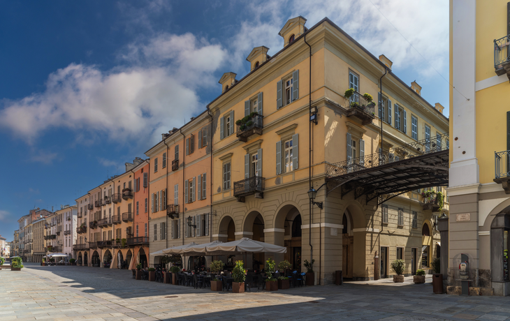 Cuneo, Piemont: Stadtansicht der Roma Street, der wichtigsten Fußgängerzone mit Kopfsteinpflaster, geschmückten historischen Gebäuden und Arkaden im historischen Zentrum.