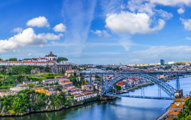 Blick auf die historische Stadt Porto in Portugal mit der Dom-Luís-Brücke und blauem Himmel 