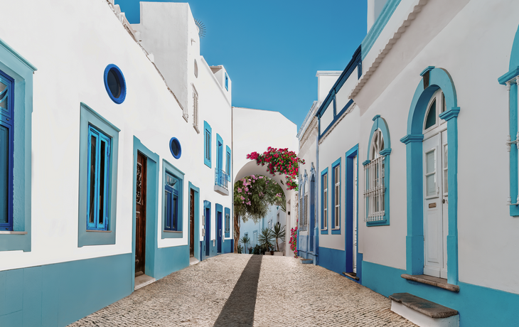 Straße in Olhão mit weißen und blauen Häusern und typisch portugiesischem Pflaster