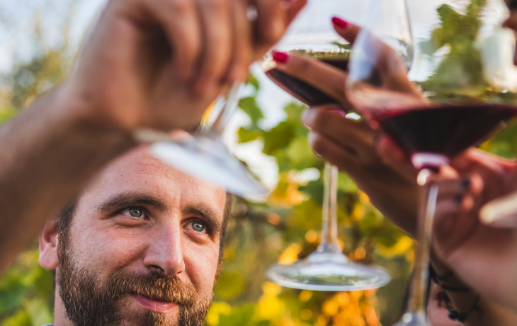 Gruppe von Menschen, die mit Gläsern Wein anstößt
