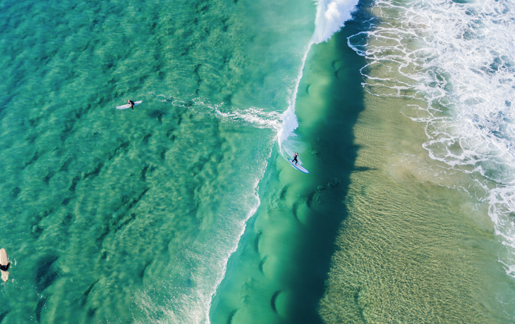 Luftaufnahme eines Surfers, der auf einer Welle reitet an der Gold Coast in Queensland, Australien