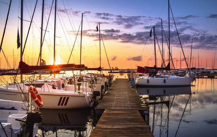 Boote, die bei Sonnenaufgang im Yachthafen am Niegocin-See anlegen, nahe Wilkasy, Masuren, Polen.